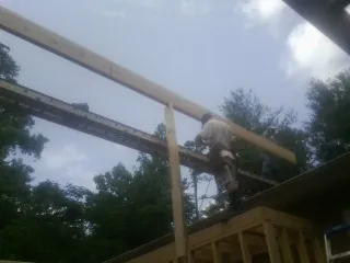 Carpenter setting a ridge beam over a new addition frame — Ice Dam Removal by Roofing Brothers in Morrow