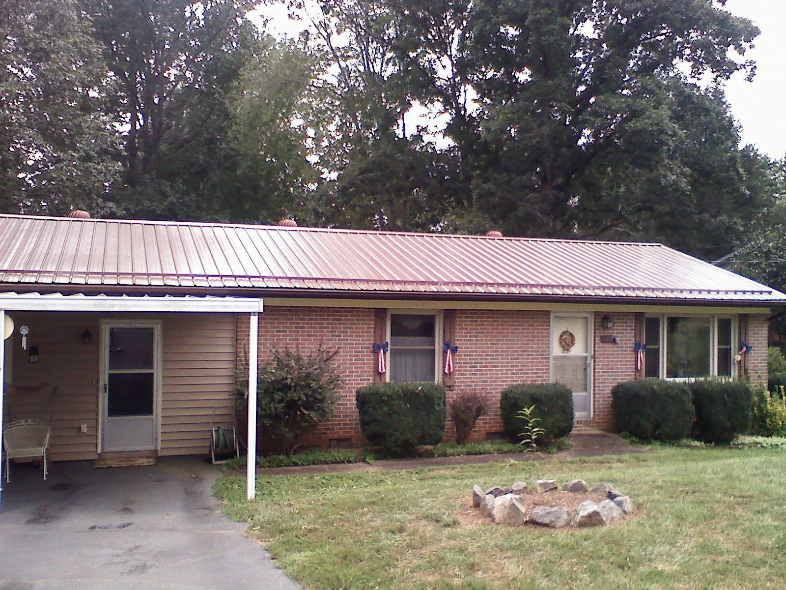 Bronze metal roof and carport on a brick ranch home — Roof Repair work by our crew in Morrow